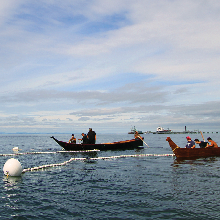 Lummi tribal members in canoes.